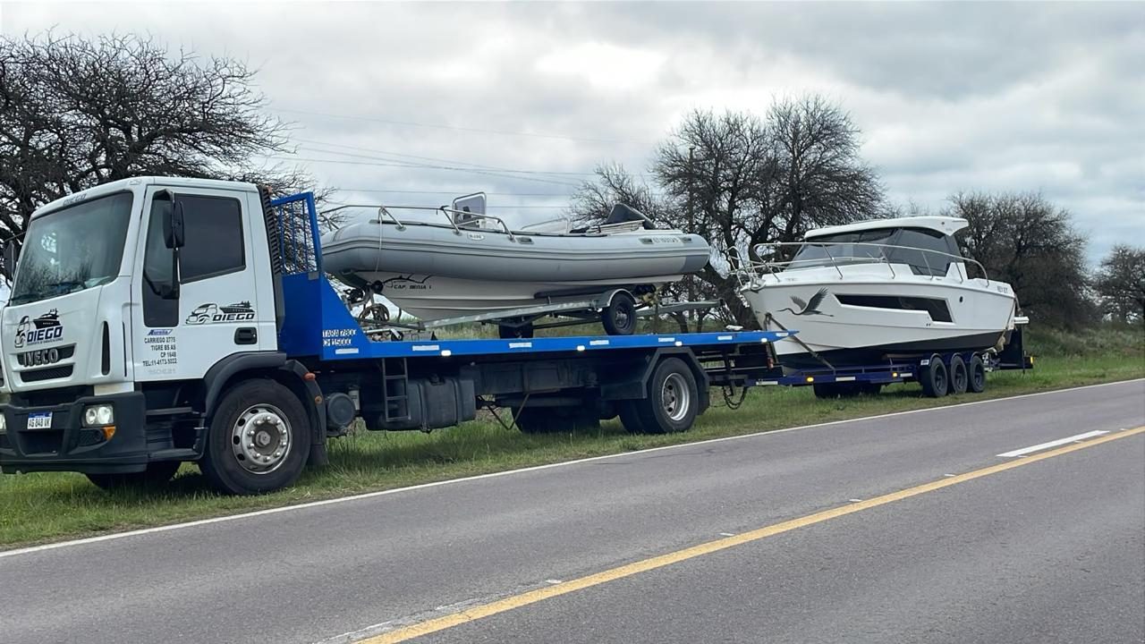Iveco con un semirrígido en la plancha y un crucero en el carretón