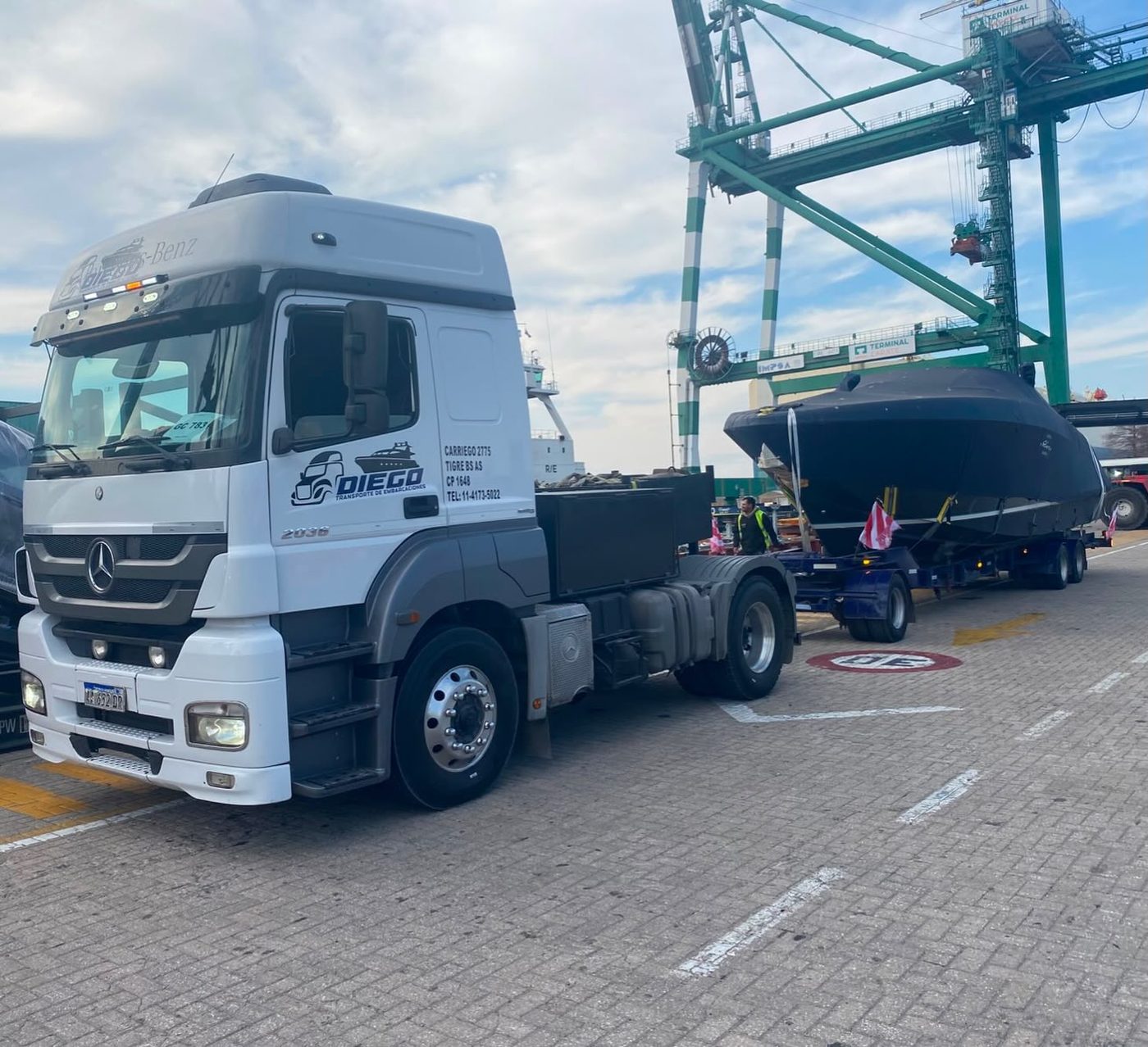 Mercedes Axor ploteado DIEGO con una lancha cubierta sobre el carretón, en el puerto de Buenos Aires